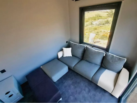 Pitch Black 7M Tiny House – geniş pencereli oturma alanı