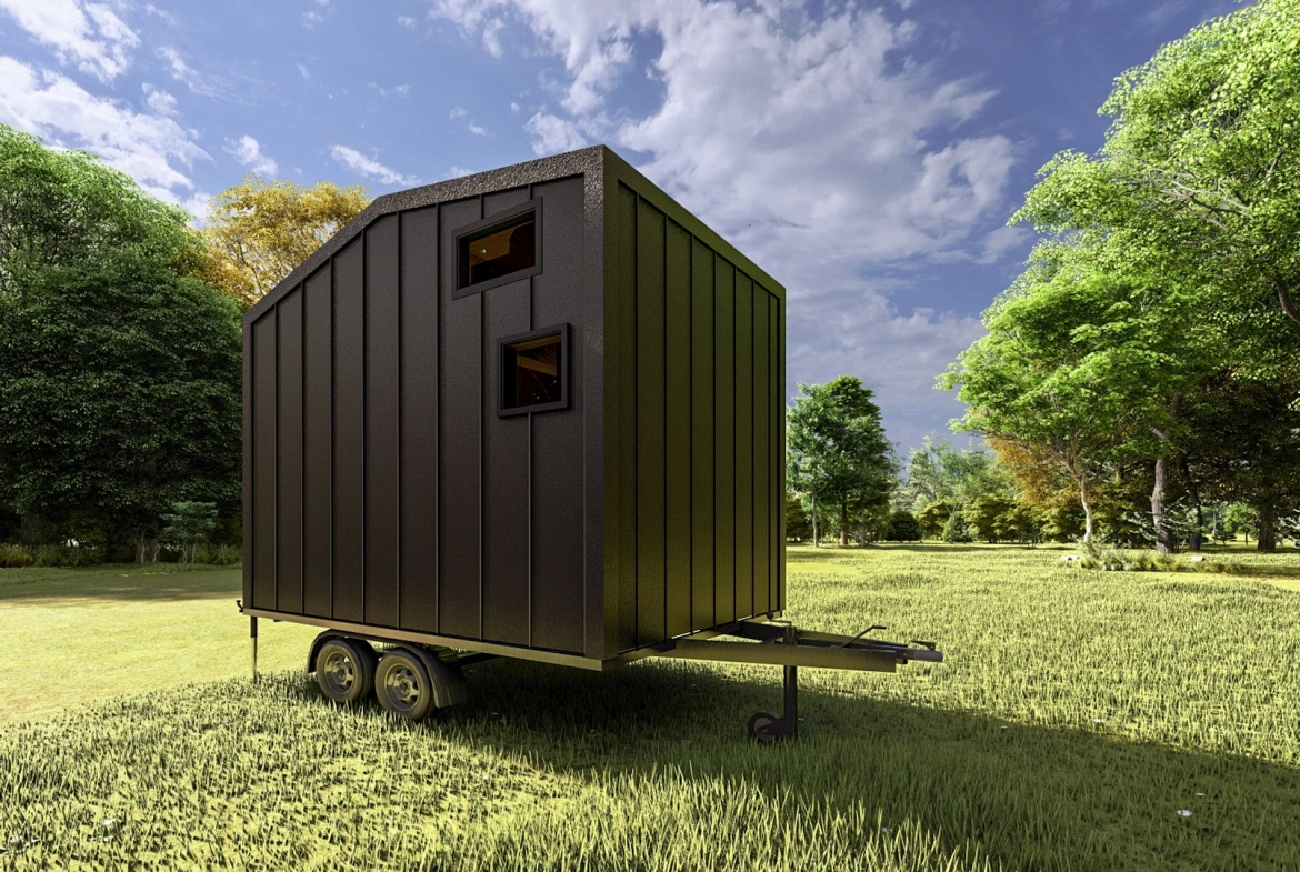 Siyah metal kaplama arka cepheye sahip tiny house, ağaçlarla çevrili geniş çimenlikte.