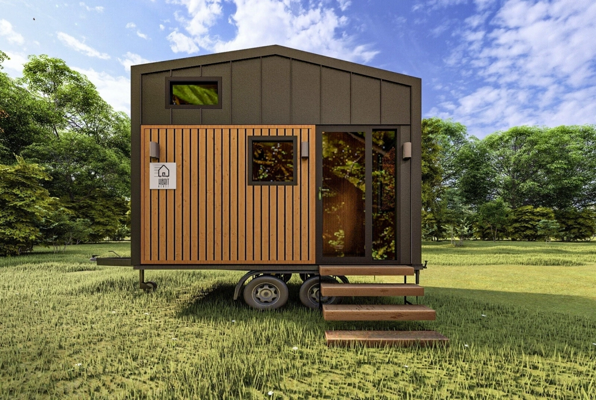 Ahşap kaplama ve siyah metal panellerle tasarlanmış tiny house’un giriş köşesi, yeşillikler içinde. Title: Giriş Köşesi – Modern Tiny House