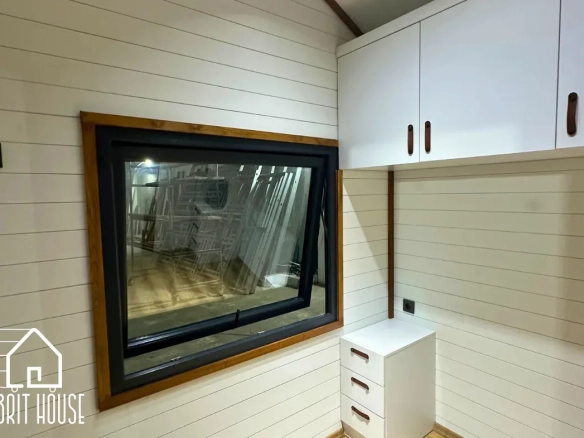 Tiny house özel tasarım yatak odası dolapları bulunuyor.Arkasında mdf beyaz paneller bulunuyor.